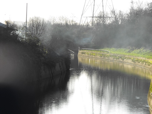 a view of a river and electricty pylon