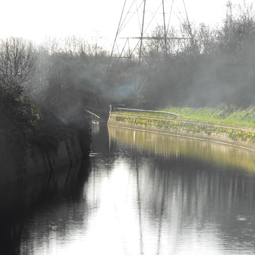 a view of a river and electricty pylon