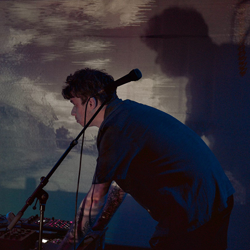 a black and white photograph showing the Degredation duo playing in front of Monty's Thames Estuary visuals